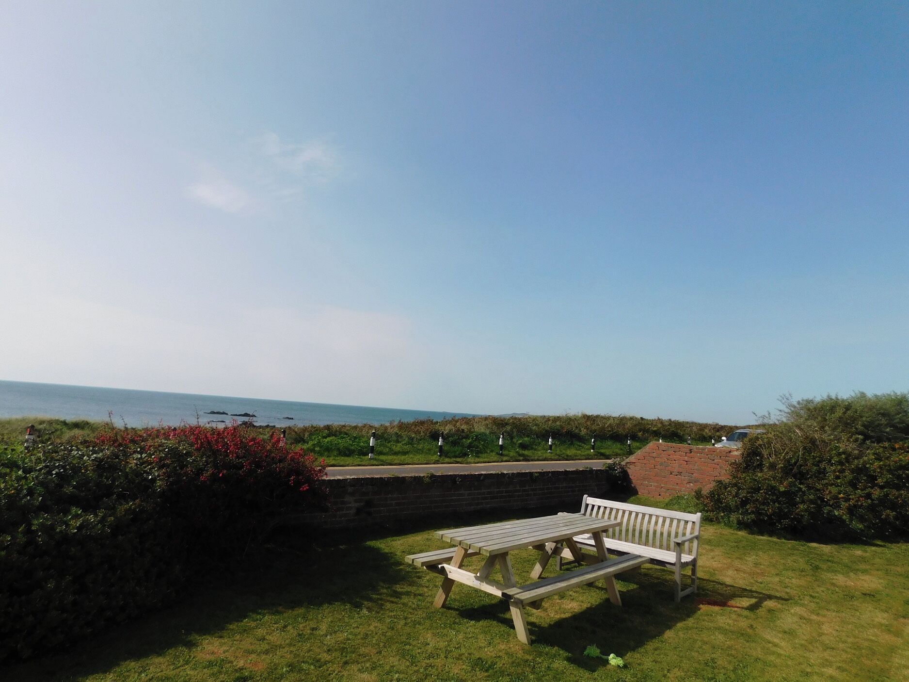 A picnic area with benches and a view of the sea.