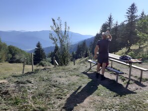 A person standing on a bench overlooking a mountainous landscape. - Charming Cottage at the Foot of the Rock (Sewen)