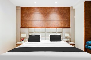 A hotel room with a large bed, two bedside tables, a wooden headboard, and a nightstand with a lamp. - Super Townhouse Chhatarpur Near Metro Park (New Delhi)