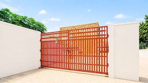 A gated entrance with a metal gate and a decorative panel. - Classic Ummed Palace (Mathura)