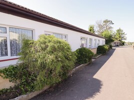 Una hilera de casas móviles blancas con ventanas grandes y un camino pavimentado.