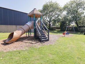 A playground with a slide, stairs, and a swing set. - Cottage 3 (Tenby)