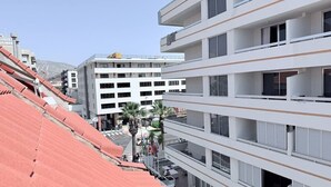 Un hôtel à plusieurs étages doté de balcons, d’un parking et donnant sur la rue.