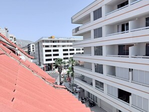 A multi-story hotel with balconies, a parking area, and a street view. - Casa Miriam Apartment (Los Cristianos)