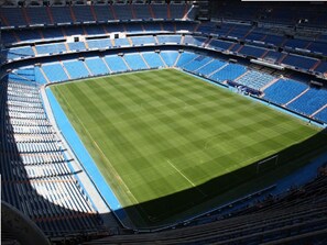 A stadium with tiered seating and a central field. - 8-guest Malasana Central Suite (Madrid)