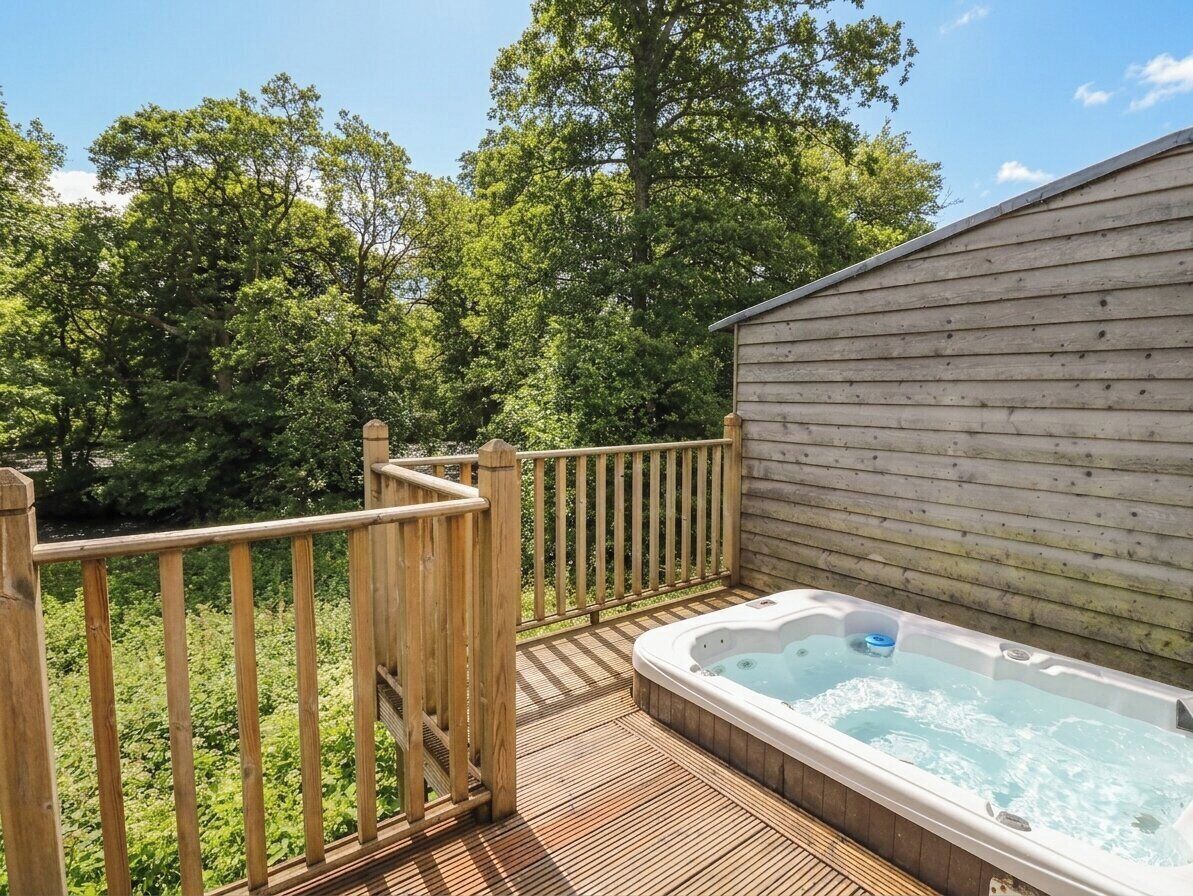 A wooden deck with a hot tub and a wooden building.