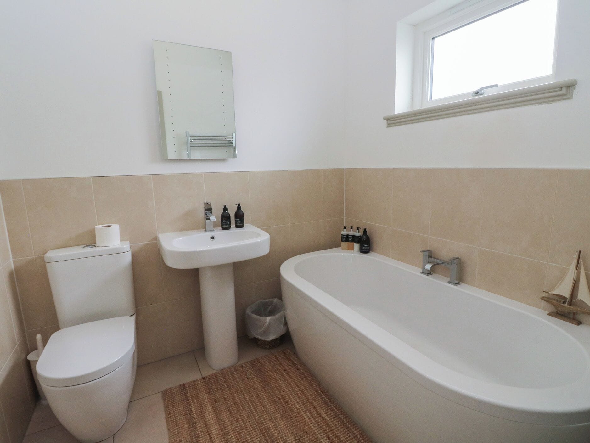 A bathroom with a toilet, sink, and bathtub.