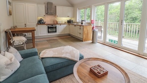 A spacious living area with a sofa, coffee table, and a view of the outdoors through large sliding glass doors.