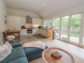 A spacious living area with a sofa, coffee table, and a view of the outdoors through large sliding glass doors.