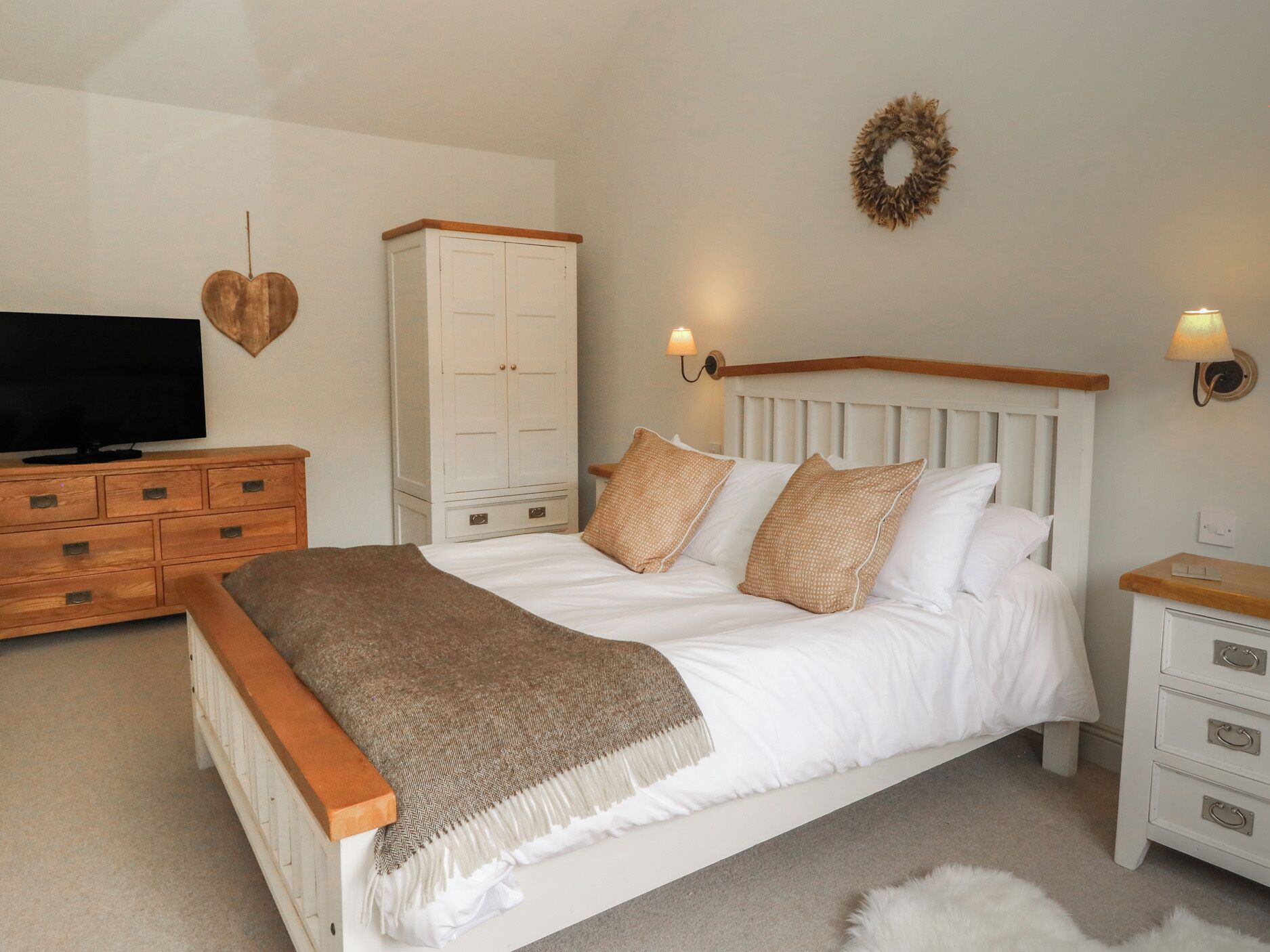 A bedroom with a bed, a TV, a wardrobe, and a nightstand.