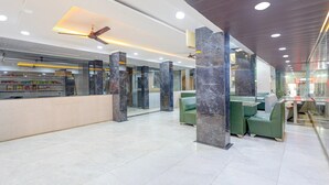 Eine geräumige Lobby mit Empfangsschalter, Sitzbereich und Deckenventilator.