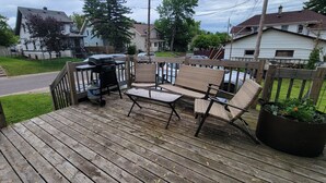 A wooden deck with a grill, wicker furniture, and a potted plant. - Pet-Friendly Duluth Basecamp Near Spirit Mountain (Duluth)