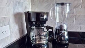 A kitchen with a coffee maker, blender, and a plate with snack packets. - Modern Apartment with Pool Near Unicentro Shopping Center (Neiva)