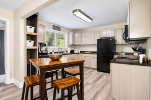 A modern kitchen with a wooden island, a black refrigerator, and a 'HOPE' sign on the wall.