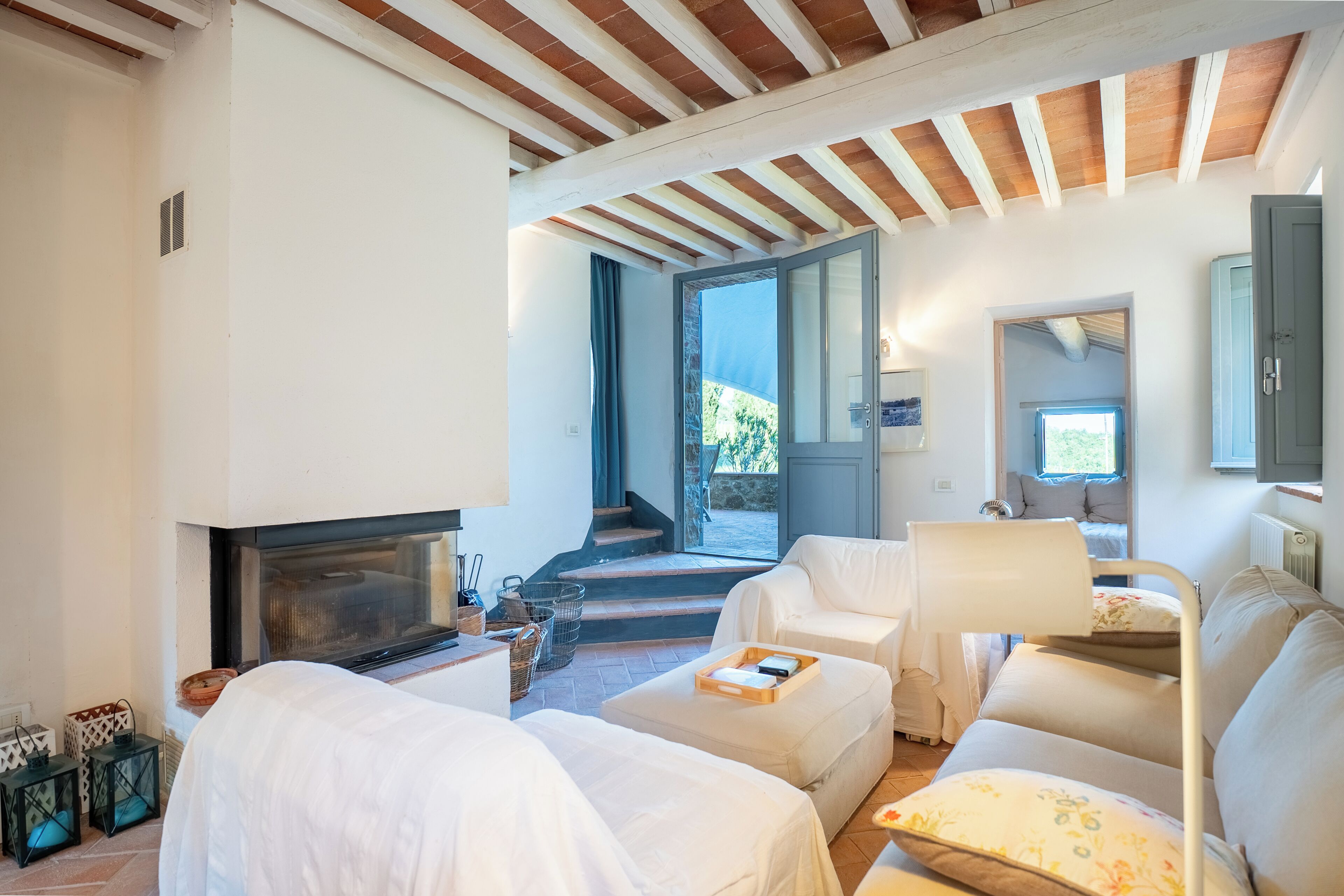 A cozy room with a fireplace, a sofa, a chair, and a lamp.