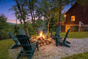 A rustic cabin with a fire pit surrounded by Adirondack chairs. - Hot Tub, Views, Firepit, Fireplace, Game Room (Banner Elk)