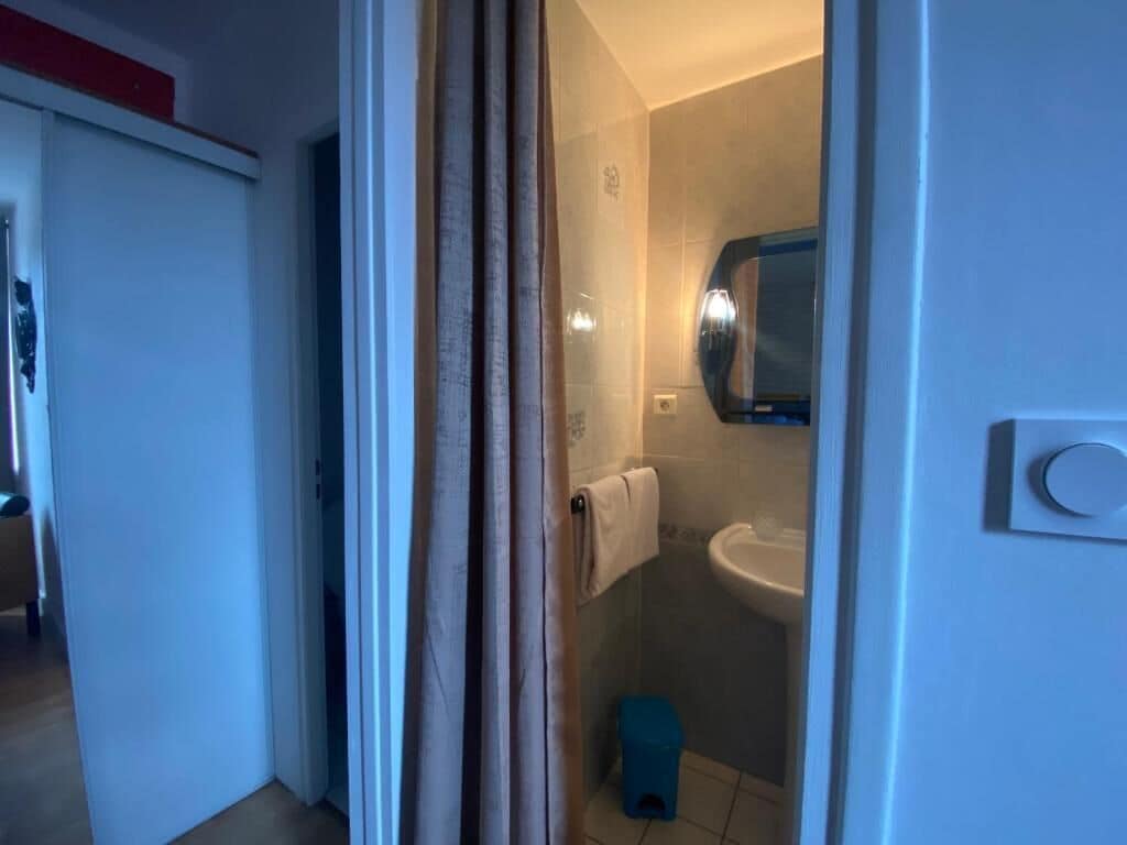 A bathroom with a shower, a sink, and a toilet.