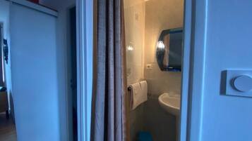 Un baño con ducha, lavamanos e inodoro.