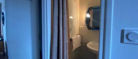 A bathroom with a shower, a sink, and a toilet.