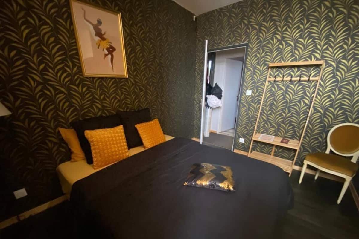 Un dormitorio con cama, espejo, armario y silla.
