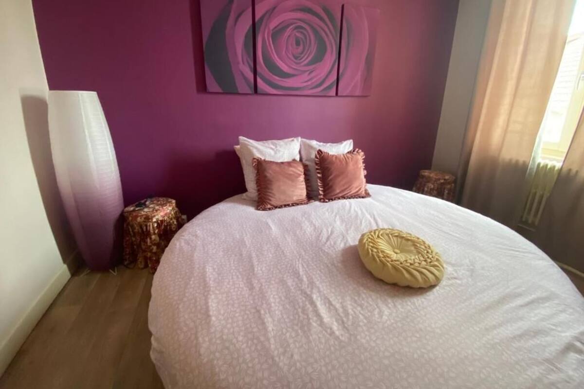 Un dormitorio con una cama grande, una obra de arte en la pared y una mesita de noche.