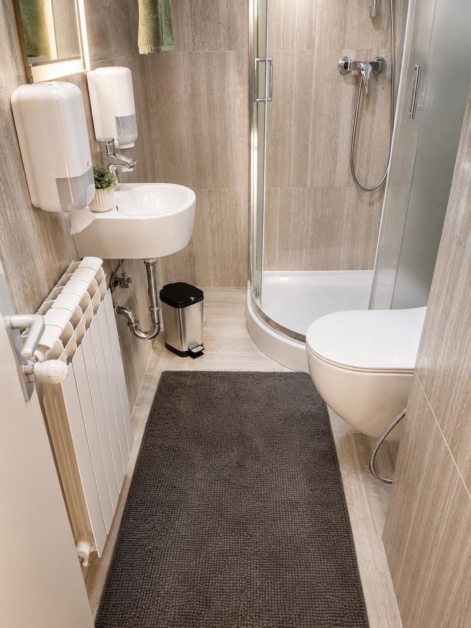 Un bagno moderno con doccia, wc e lavandino.