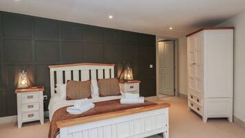 A bedroom with a bed, bedside tables, a wardrobe, and a door.