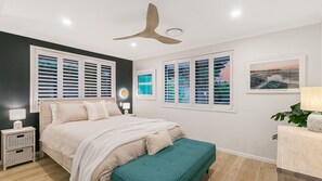 A bedroom with a bed, bedside tables, a ceiling fan, and windows with blinds. - Salthill - Waterfront Pet Friendly Family Home on the Tweed River - Min 3N (Tweed Heads)