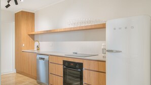 Une cuisine moderne équipée d’un lave-vaisselle, d’un four et d’un réfrigérateur blanc.