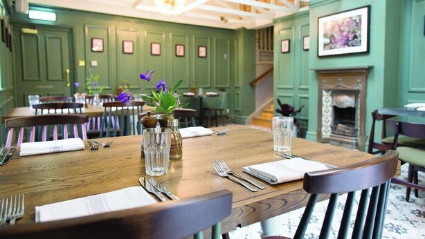 A dining area with wooden tables, chairs, and a fireplace. - Gorgeous 2 bedroom Kintbury cottage (Kintbury)