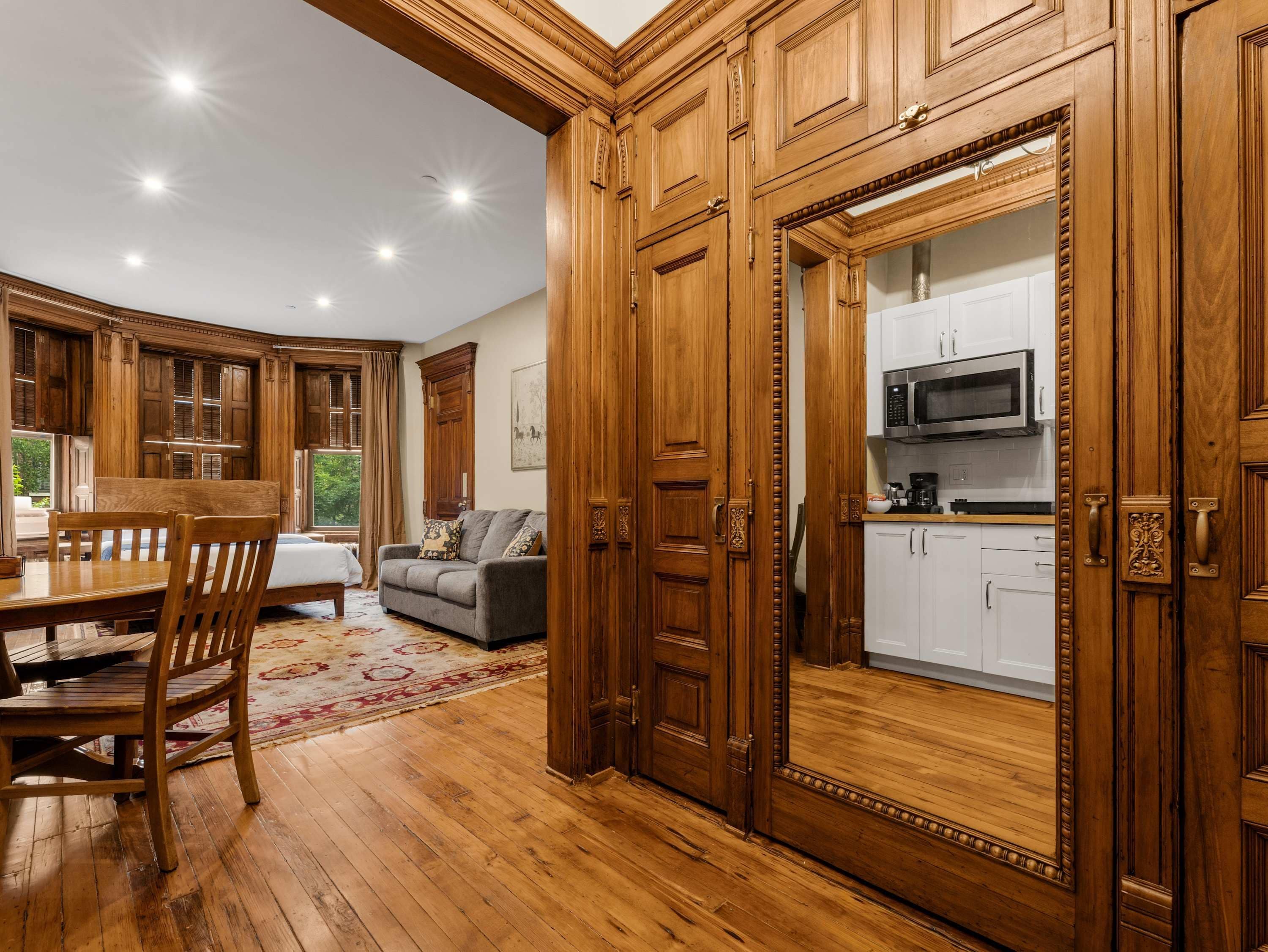 Una cocina amplia con armarios de madera, un comedor con mesa y sillas de madera, y una sala de estar con sofá y alfombra.