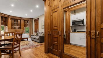 Una cocina amplia con armarios de madera, un comedor con mesa y sillas de madera, y una sala de estar con sofá y alfombra.