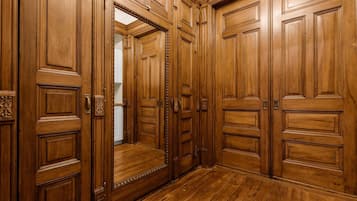 Un pasillo de madera con varias puertas y suelo de madera.