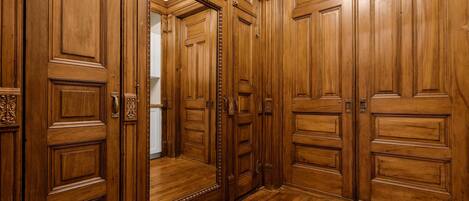 Un pasillo de madera con varias puertas y suelo de madera.