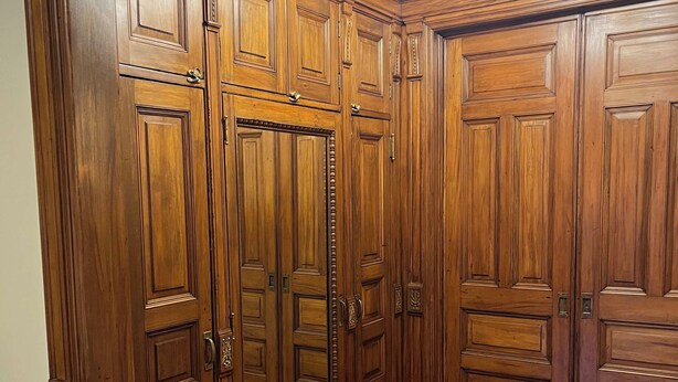Una habitació amb revestiment de fusta, un lampadari i un sòl de fusta.