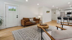 Een moderne woonkamer met een bank, een bijzettafeltje en een vloerkleed.