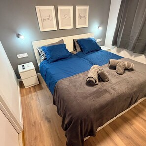 Tabla de planchar con plancha, internet y ropa de cama