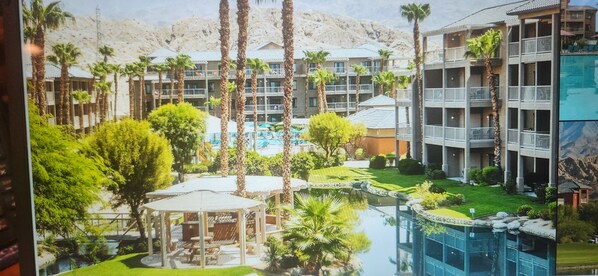 Een resort met meerdere gebouwen, een zwembad en palmbomen.