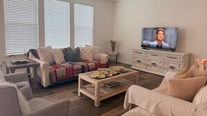 A living room with a sofa, coffee table, and television.