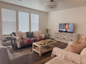 Ein Wohnzimmer mit Sofa, Couchtisch und Fernseher.
