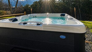 A hot tub with a clear view of the sky and trees in the background. - 8BR Luxury Farmhouse · Waterfall · Hot Tub · Catskills (Ellenville)