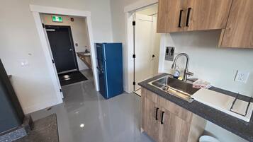Een moderne keuken met een spoelbak, kasten en een blauwe koelkast.