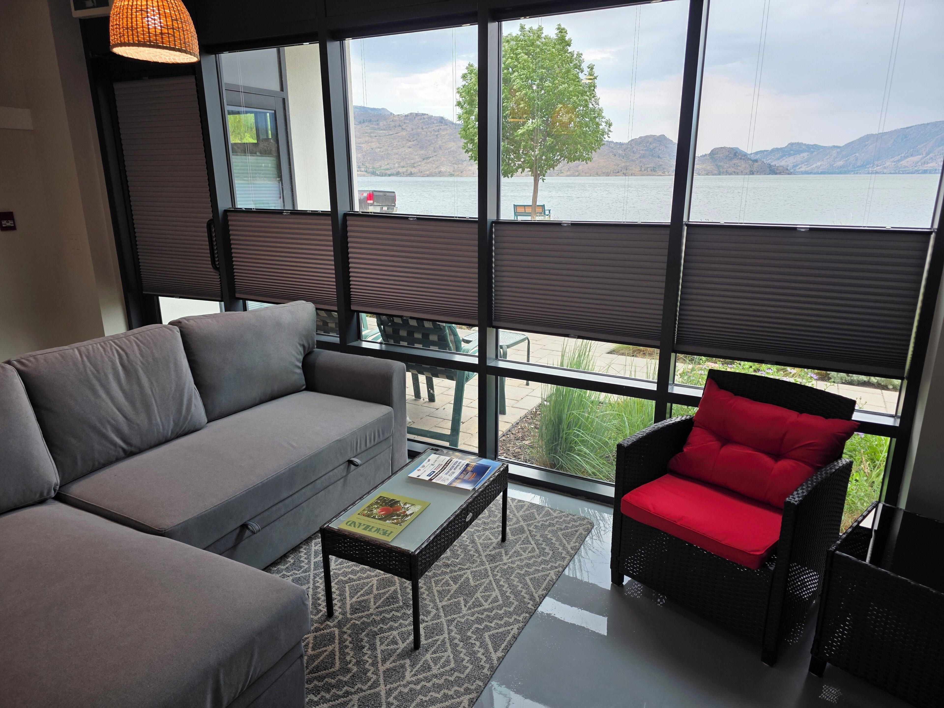 A modern living room with a sofa, a red chair, and a coffee table.