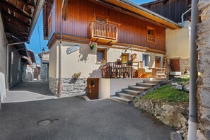 A traditional wooden building with a balcony, stone steps, and a sign indicating a restaurant. - Le Planay. Chambéranger – Apartment in a Traditional Savoyard Village (Planay)
