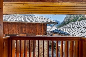 A wooden balcony with a view of traditional buildings and mountains. - Le Planay. Chambéranger – Apartment in a Traditional Savoyard Village (Planay)