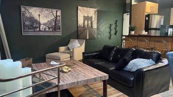 A modern living room with a sofa, a coffee table, and artwork on the wall.