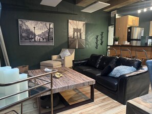 A modern living room with a sofa, a coffee table, and artwork on the wall.
