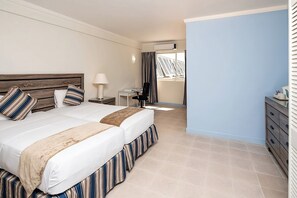 Habitación de hotel con una cama grande, un escritorio y vistas al exterior.