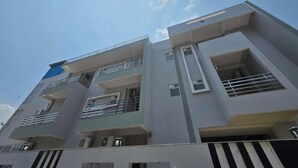 A multi-story building with balconies, air conditioning units, and a clear sky. - Classic Pine Villa (Lucknow)