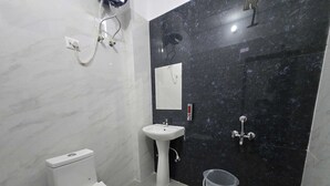 A bathroom with a toilet, sink, and shower. - Classic Pine Villa (Lucknow)